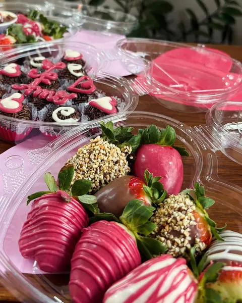 Morangos cobertos com chocolate e doces decorados para festa
