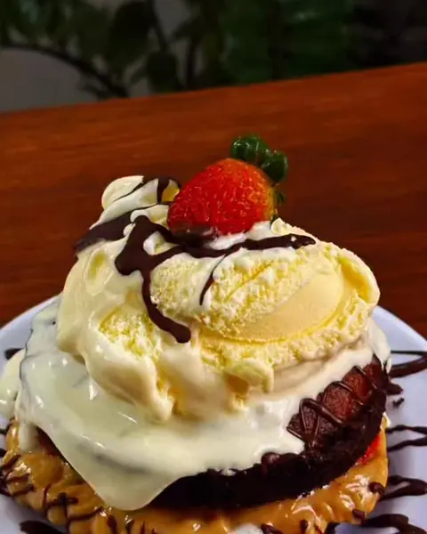 Sobremesa com sorvete, calda de chocolate e morango